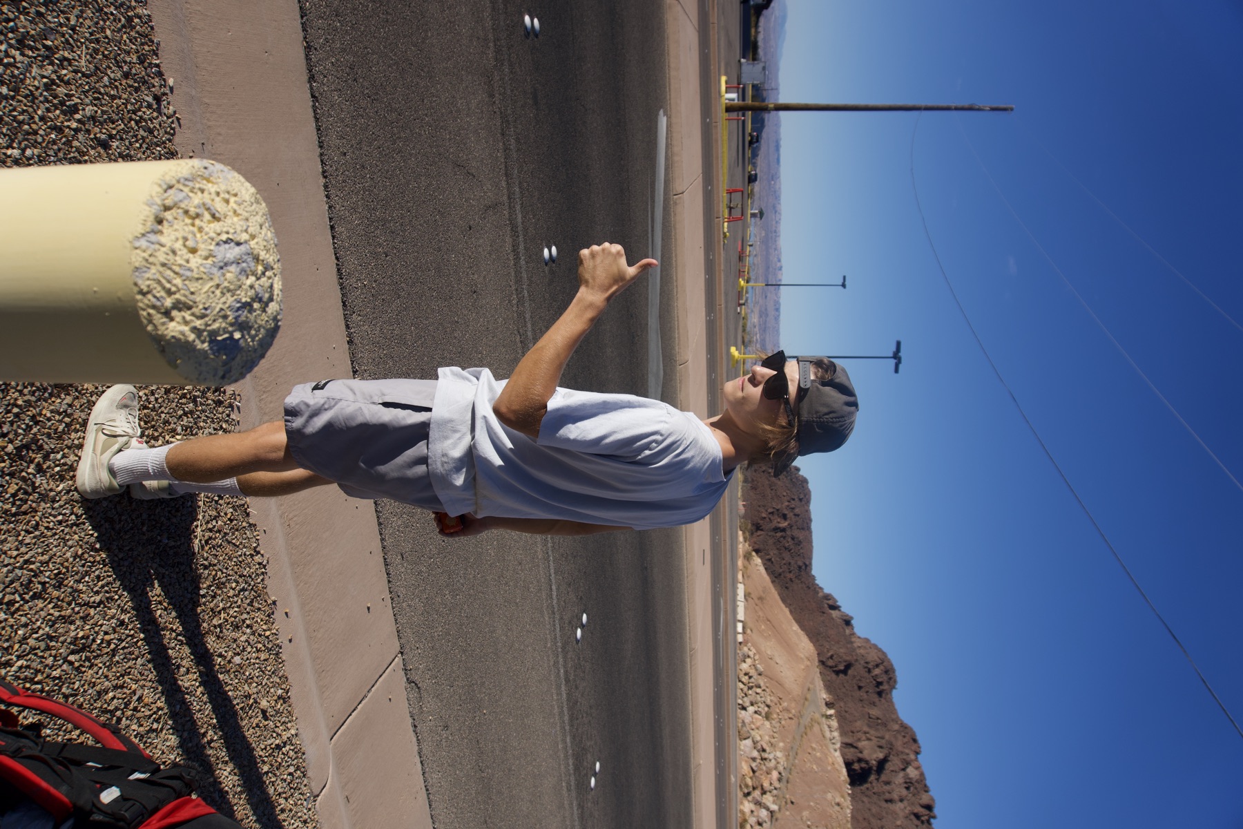 Thumb out on the desert highway with the hills behind us