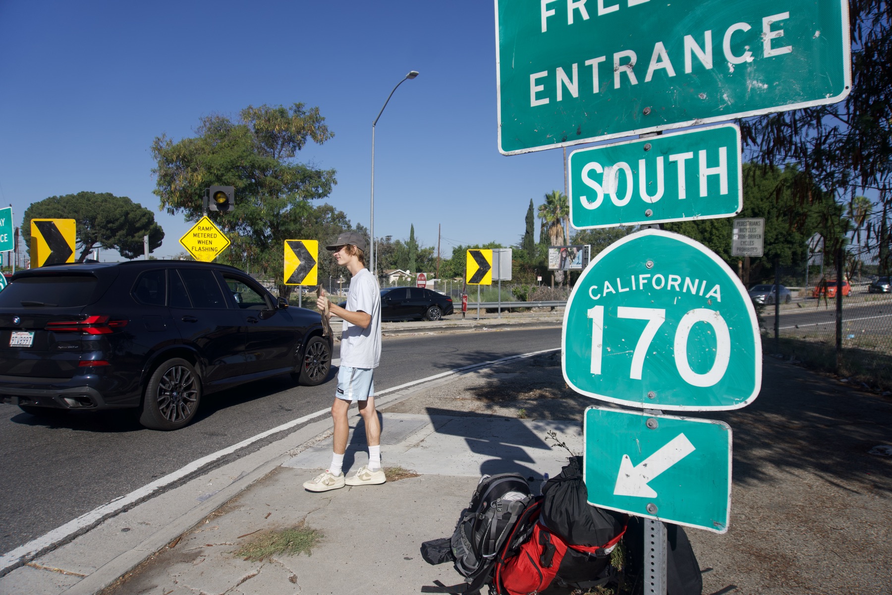 Thumb out at the Freeway Entrance, 170 South, with our packs by the curb